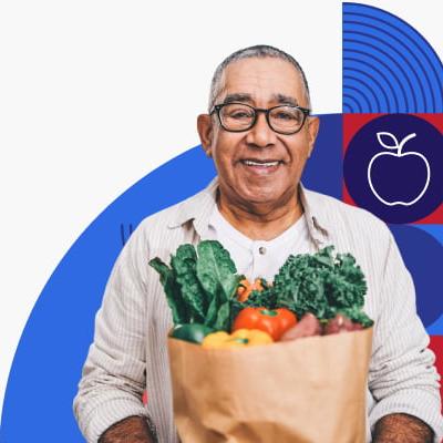 A man holding a paper bag filled with vegetables.